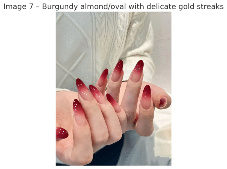 Glossy burgundy nail designs with nude accent nails featuring glitter and floral detailing. Festive nail design.