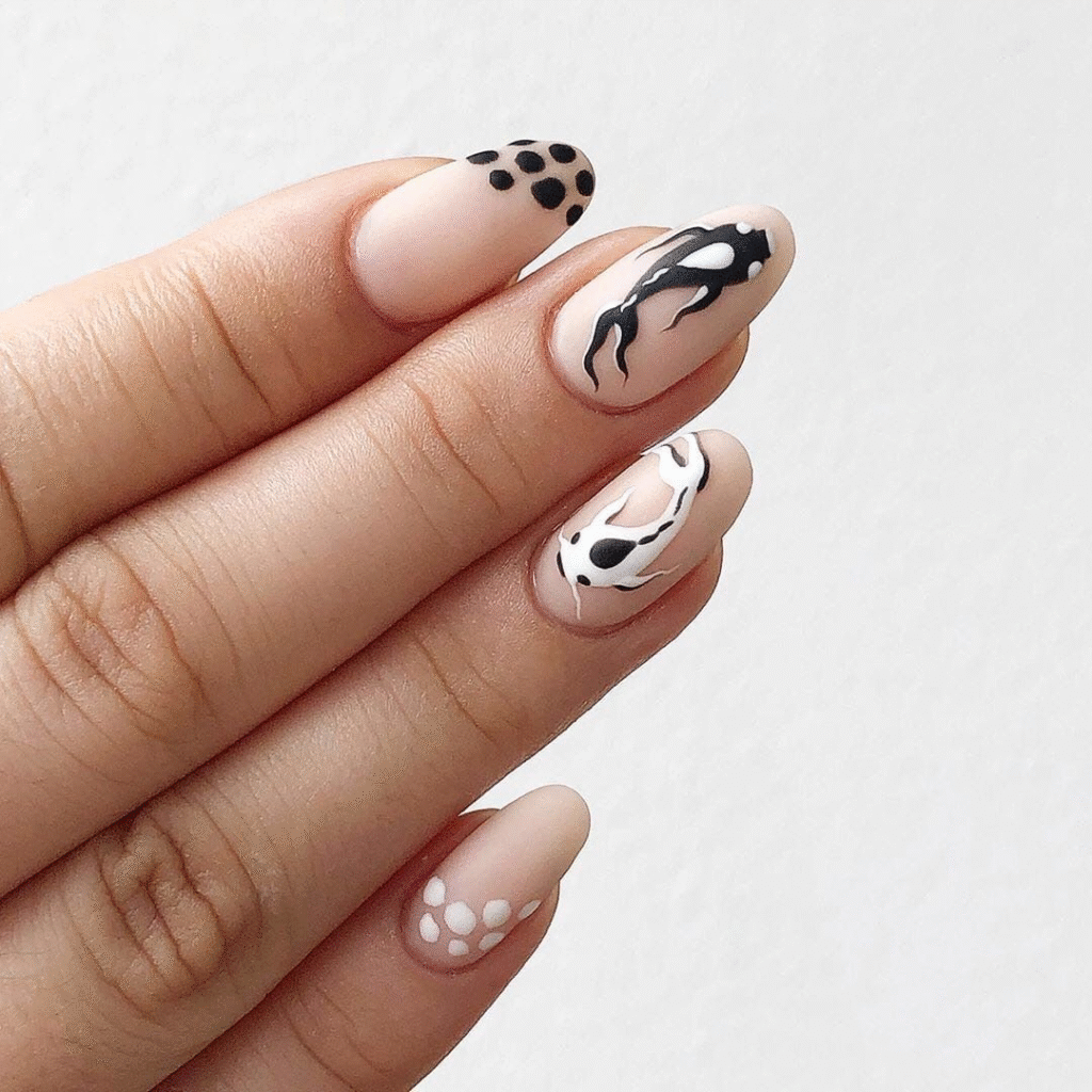 Halloween nails with spooky black cat designs and eyes, featuring a nude base for a cute and playful Halloween look.