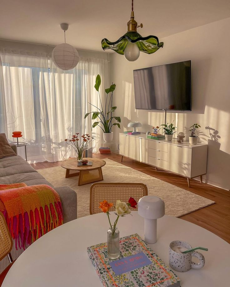 A bright and airy living room design with light wooden flooring, white walls, and colorful accents creating an inviting and vibrant space.