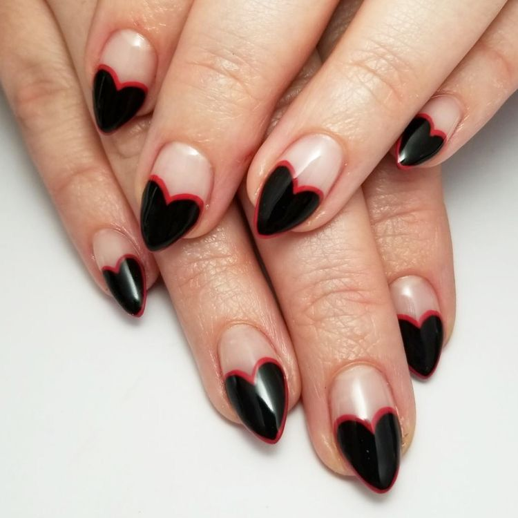 Negative-space heart French nails—glossy black hearts edged in scarlet on nude base for a bold, graphic manicure.