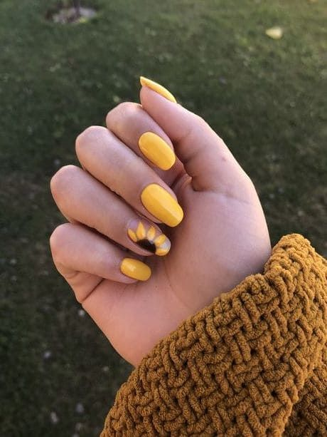 glossy yellow sunflower nails with ombre accent and single sunflower art, short round shape