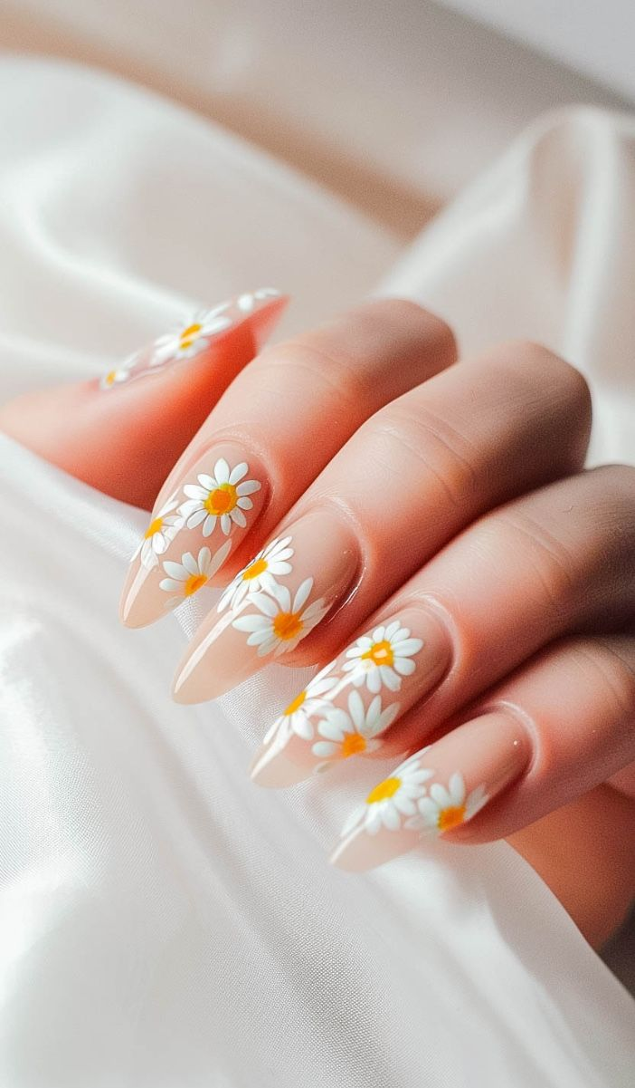 long almond yellow sunflower nails with scattered white daisies on nude base, bridal satin backdrop