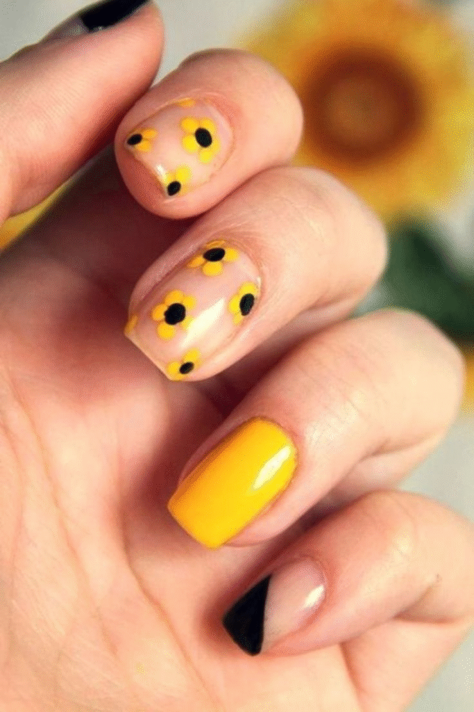 minimal yellow sunflower nails with micro French tips and side sunflower detail on almond nails