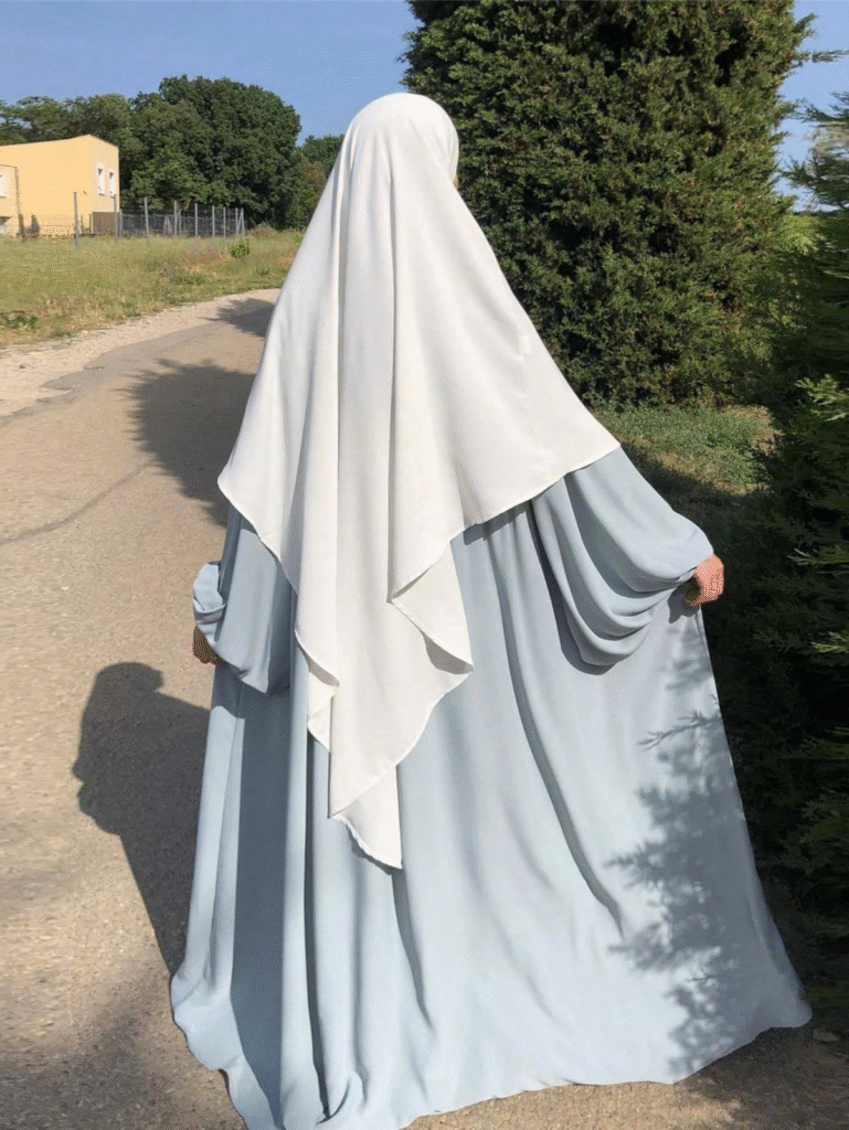 jilbab outfit with ivory khimar and cloud blue abaya, modest fashion outdoor photo, flowing layers from back view