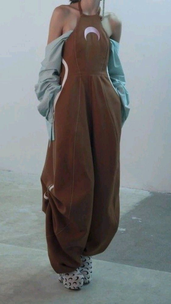 brown sculptural wide-leg jumpsuit with halter neck and crescent detail, styled with platform boots