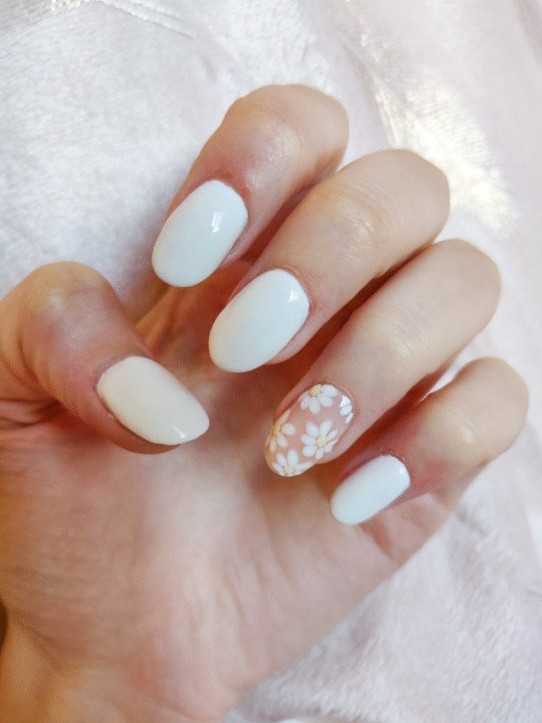 short white nails with single daisy floral accent on nude base, rounded shape