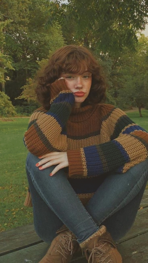 winter comfort dresses casual — chunky striped knit sweater in earthy tones with skinny jeans and lace-up boots in the park