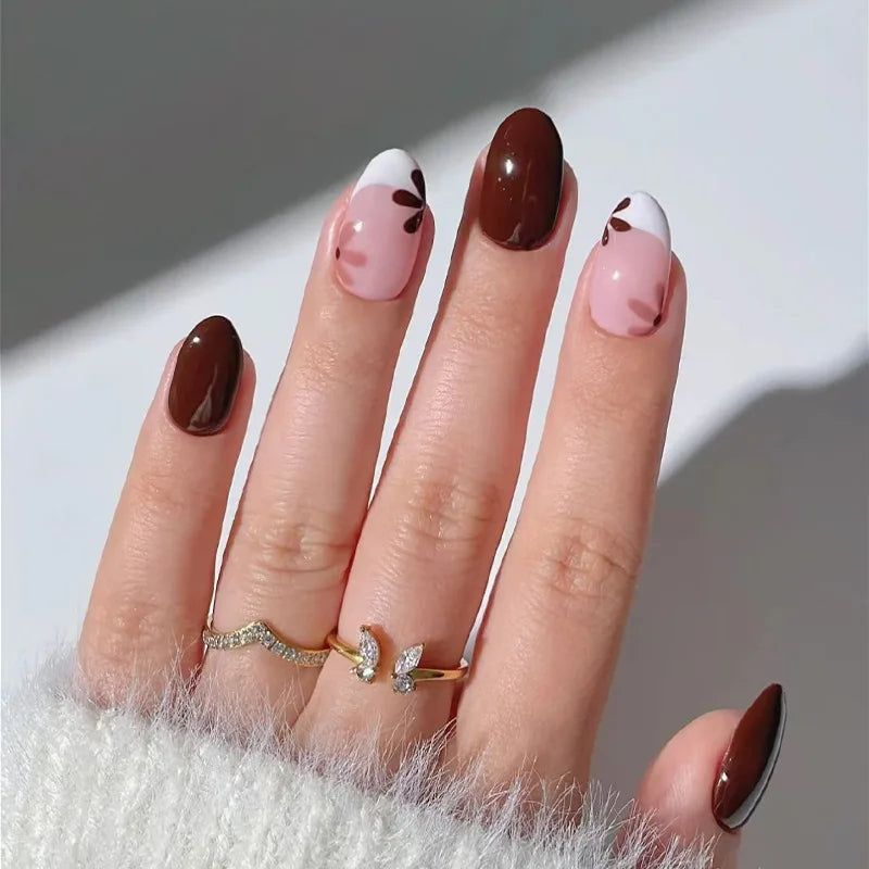 Chocolate brown and blush pink press on nails with white French swoop and leaf-petal accents.