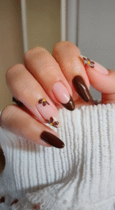 Nude press on nails with mocha French tips and mini brown daisies with yellow centers.