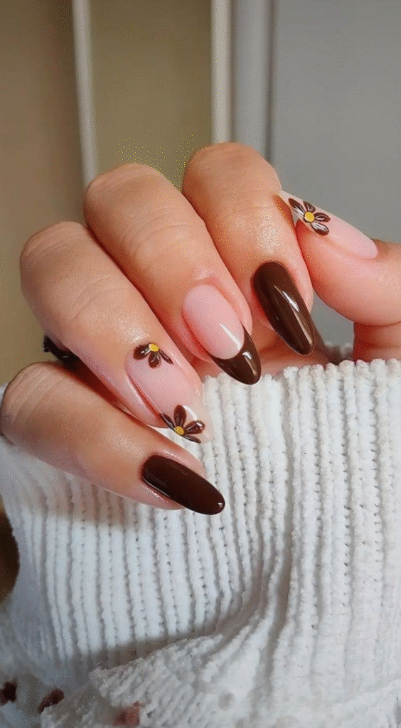 Nude press on nails with mocha French tips and mini brown daisies with yellow centers.