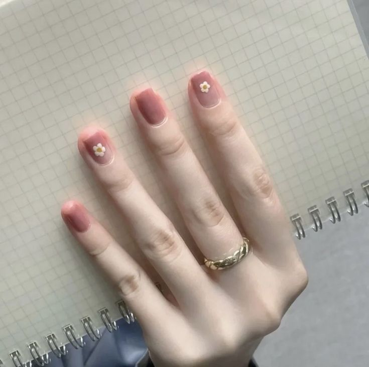 Short rosy jelly nails featuring tiny white daisy accents at the cuticle—soft micro floral manicure.