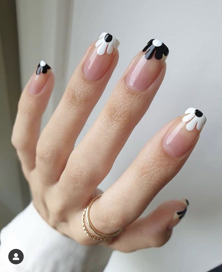 Soft-square nude nails with black-and-white petal drip French tips; minimalist, glossy finish.