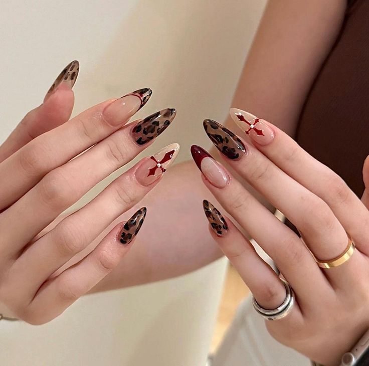 Mixed almond set with tortoiseshell tips, nude negative space, and burgundy accent nail with dainty star dots.