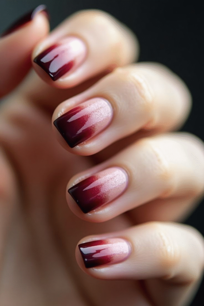 Close-up of short square nails with a rosy base fading into glossy espresso tips.