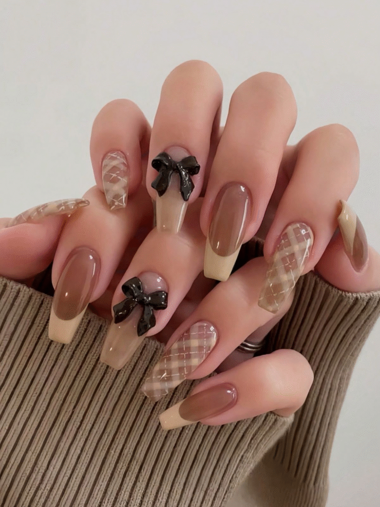 Long neutral nails with plaid design and sculpted black bow accents.