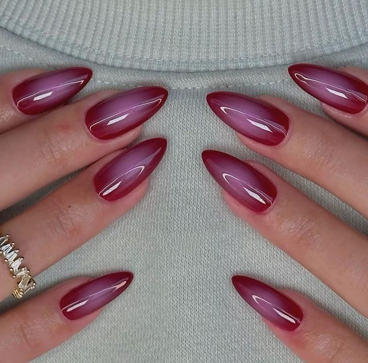 Cherry red cat-eye nails with a luminous center highlight; glossy topcoat.