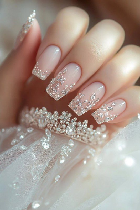 Square bridal nails with sheer nude base and scattered clear crystals; glossy French-style sparkle.