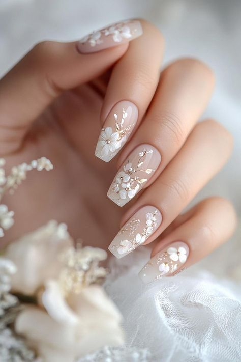 Square nude French nails with delicate white flowers and fine gold branches.