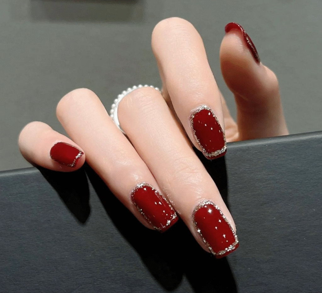 Short red nails with glitter outline