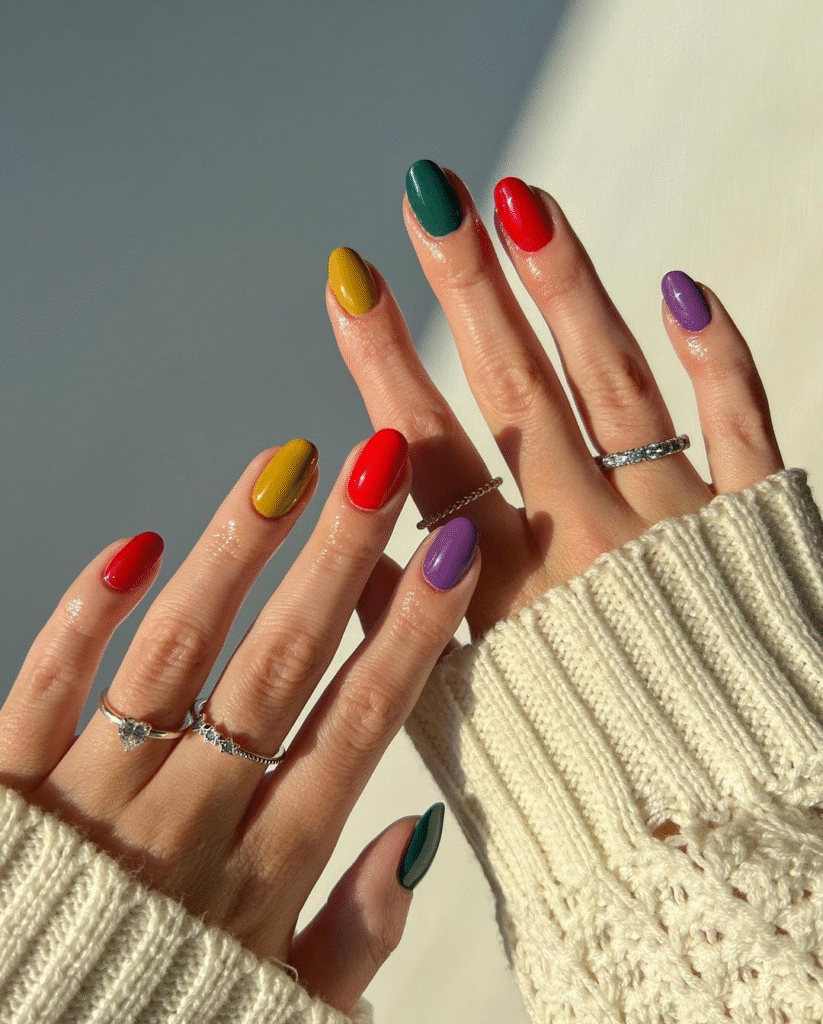 Skittle / Mismatched palettes primary color nails in natural light with cozy sweater and rings.